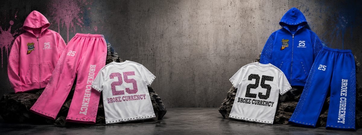 Two coordinated streetwear outfits displayed side by side against a dark textured wall: a pink hoodie and matching pink pants on the left, and a blue hoodie with white pants on the right. Each set includes a white T-shirt with the number 25 and the text BROKE CURRENCY.